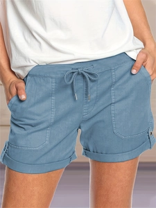 Dettaglio di pantaloncini estivi blu con vita a coulisse e grandi tasche applicate