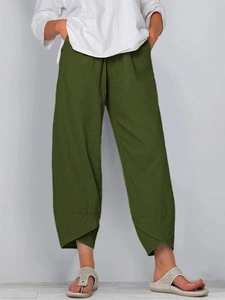 Detail showing the cross-over hem and textured linen fabric of the olive green pants