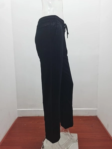 Detail of black cotton linen trousers showing elastic drawstring waist and side pockets