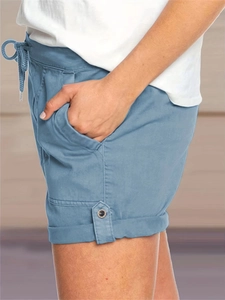Dettaglio degli shorts casual azzurri con tasche laterali e orlo risvoltato con bottone