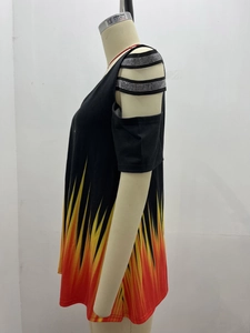 Detail of cold-shoulder sleeve with rhinestone straps and vibrant flame print on black top