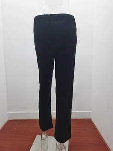 Detailed view of black linen trousers featuring an elastic drawstring waistband and loose fit