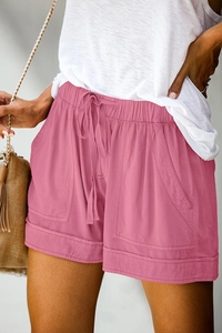 Close-up of rose pink high-waisted shorts with drawstring and large utility pockets
