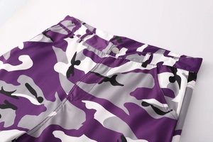 Dettaglio della vita dei pantaloni cargo mimetici viola con bottone e zip in vista