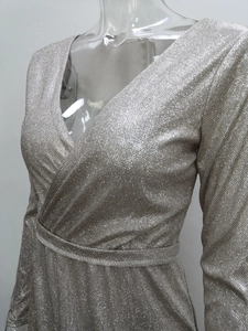 Detailed view of silver long sleeve V-neck dress featuring metallic glitter fabric and waist belt