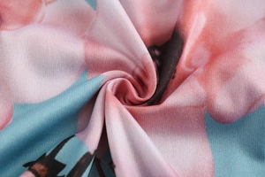 Detailaufnahme von Blumendruck-Stoff mit rosa und blauen Tönen und feiner Textur