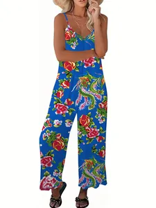 Detail of tropical floral print and thin straps on bright blue wide-leg jumpsuit