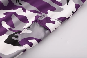 Dettaglio ravvicinato della tasca cargo con motivo mimetico viola e design a patta