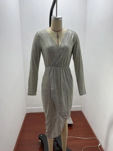 Detailed view of silver sequin dress with deep V-neck and high waist draped details