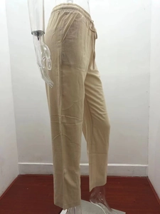 Detailed view of elastic drawstring waistband and textured fabric on casual linen trousers