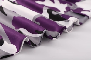 Dettaglio ravvicinato di tessuto mimetico viola con trama a saia e pieghe