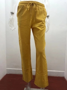 Detail of ginger yellow linen pants featuring elastic drawstring waist and breathable fabric