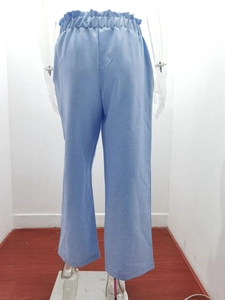 Close-up of light blue cotton linen trousers featuring an elastic pleated waistband