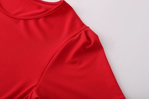 Détail du haut rouge à col rond montrant la maille élastique et la couture précise