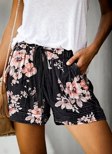Detail of floral printed summer shorts showing elastic drawstring waist and side pockets