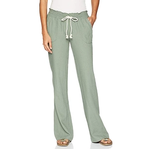 Detail of sage green linen trousers featuring elastic waistband and white cotton drawstring