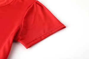 Dettaglio delle cuciture a doppio ago sul polsino e sulla spalla di questo abito rosso