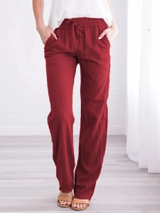 Detail of red cotton linen trousers showing drawstring waist and side pockets for women