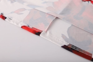 Détail de l'imprimé floral rouge et des coutures fines sur l'ourlet de la chemise