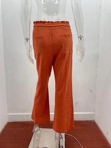 Detail view of orange cotton linen wide leg trousers featuring high elastic waist and back pockets
