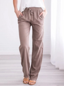 Detail view of khaki cotton linen trousers featuring elastic drawstring waist and side pockets