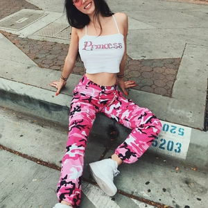 Dettaglio di pantaloni cargo mimetici rosa e top corto bianco con stampa Princess da donna