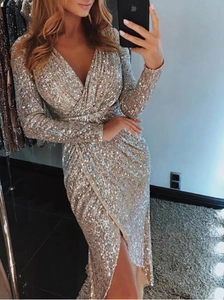 Detail of champagne gold sequin dress featuring deep V-neck, waist pleats, and side slit