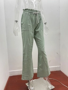 Detail of sage green wide-leg pants with elastic drawstring waist and patch pockets
