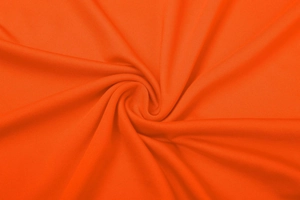 Dettaglio macro del tessuto a maglia arancione brillante con fine trama a nido d'ape ed elastico