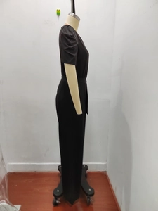 Detail of the elegant black short sleeve jumpsuit showing waistline and fluid fabric texture
