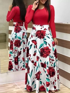 Détail d'une robe élégante rouge à manches longues, taille haute et jupe fleurie évasée