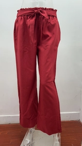 Detail of red high waist paper bag trousers with matching belt and ruffled waistband