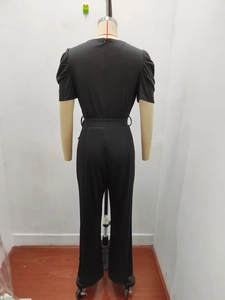 Detail view of the black short sleeve jumpsuit showing puffed sleeves and back waist design
