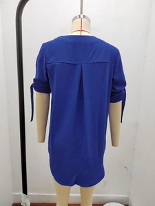 Dettaglio della camicetta in chiffon blu navy con piega posteriore e polsini con fiocco