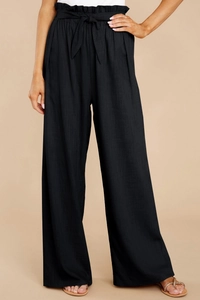 Detail of high waisted paper-bag waist and linen fabric texture on black wide leg trousers