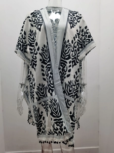 Détails de l'imprimé floral bohème et des pompons sur ce cardigan de plage kimono