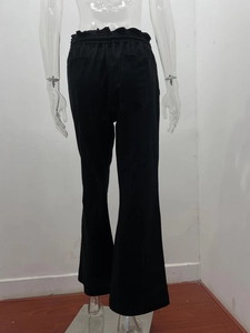 Detail view of black linen pants featuring an elastic waist and dual back patch pockets