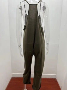 Detail view of the back of a loose-fitting dark green jumpsuit with thin shoulder straps
