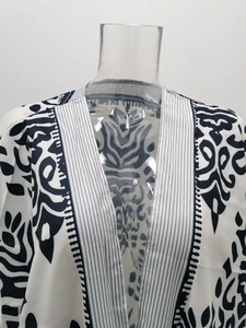 Détail d'un cardigan kimono bohème à imprimé floral noir et blanc avec bordure rayée