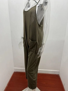 Detail of dark olive green loose fit jumpsuit with thin straps and large front pockets