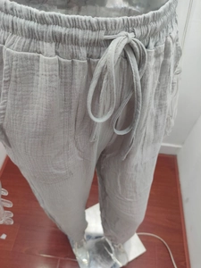 Detail of grey casual high waist pants featuring elastic drawstring waist and pocket texture