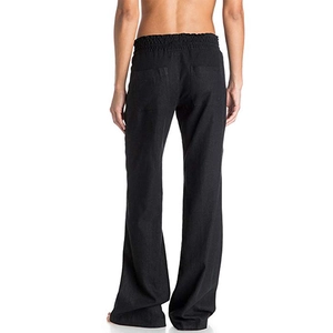 Detail view of high waist elastic waistband and back pockets on black linen wide leg trousers