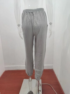 Detail of light grey drawstring waist joggers with vertical textured fabric and elastic cuffs
