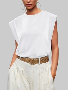 Detail of white muscle tee with padded shoulders paired with a high waist beige trouser