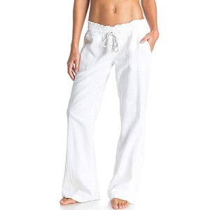 Detail of white cotton linen trousers featuring elastic drawstring waist and side pockets