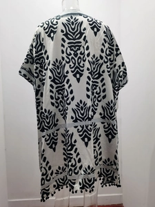 Vue détaillée de l'imprimé floral noir et blanc et des pompons sur l'ourlet du kimono long