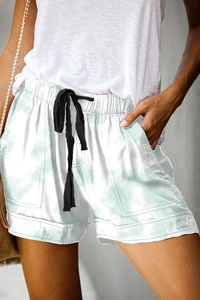 Detail view of high-waisted casual shorts with marble pattern and black drawstring closure