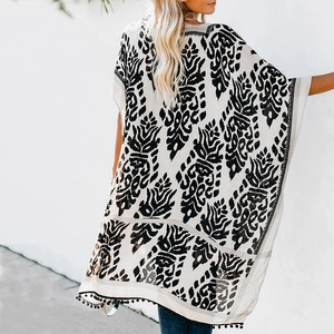 Vue arrière du cardigan kimono bohème avec imprimé damassé noir et bordure à pompons