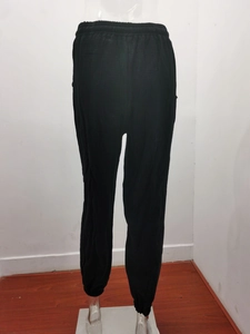 Detail view of black high waist casual trousers with elastic waistband and drawstring tie