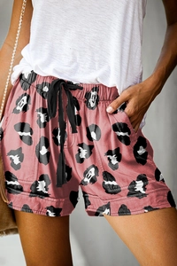 Detail of coral pink summer shorts featuring abstract leopard print and drawstring waist